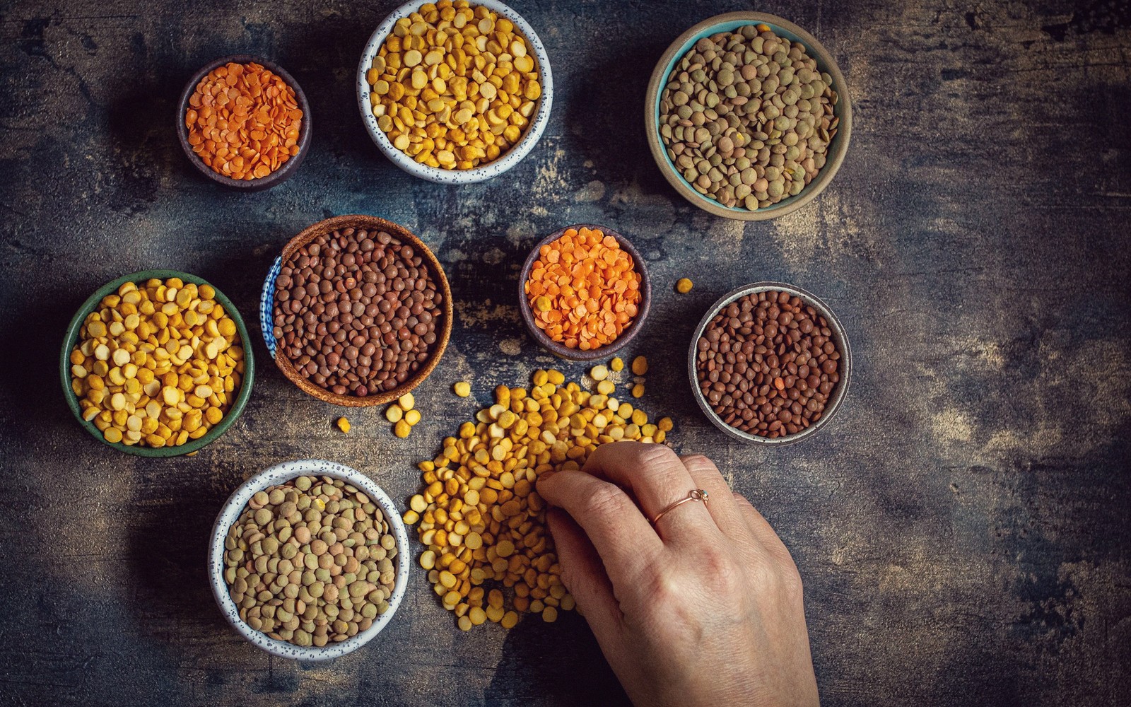Dried pulses in bowls, overhead.